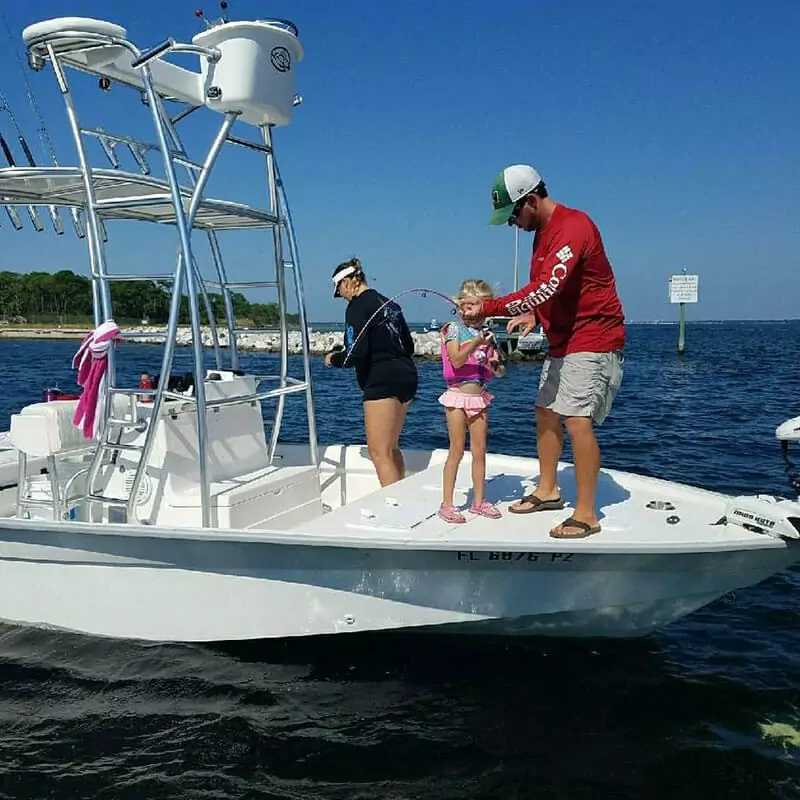 family fishing on a small white boat